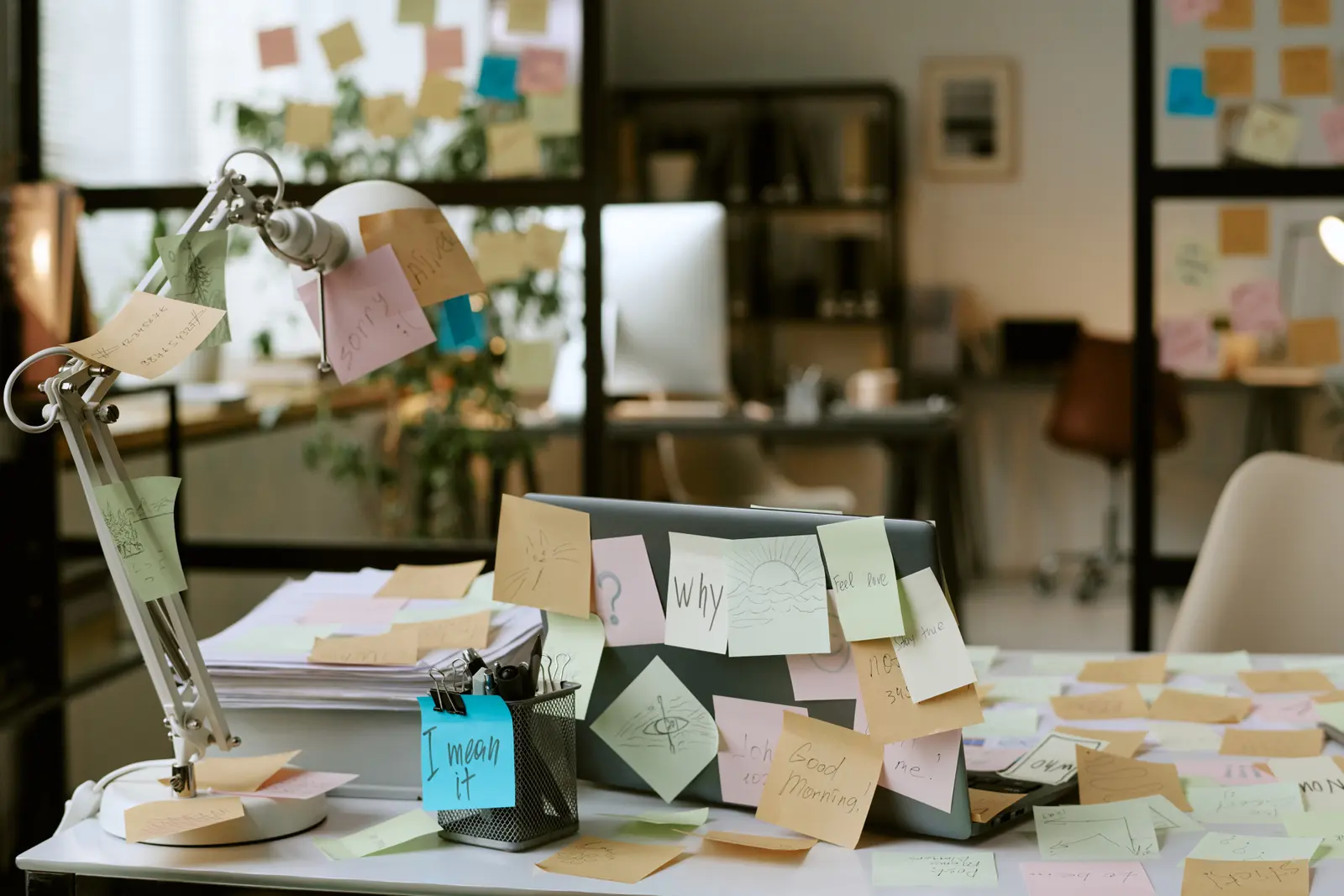 Desk covered in sticky notes and to-do lists